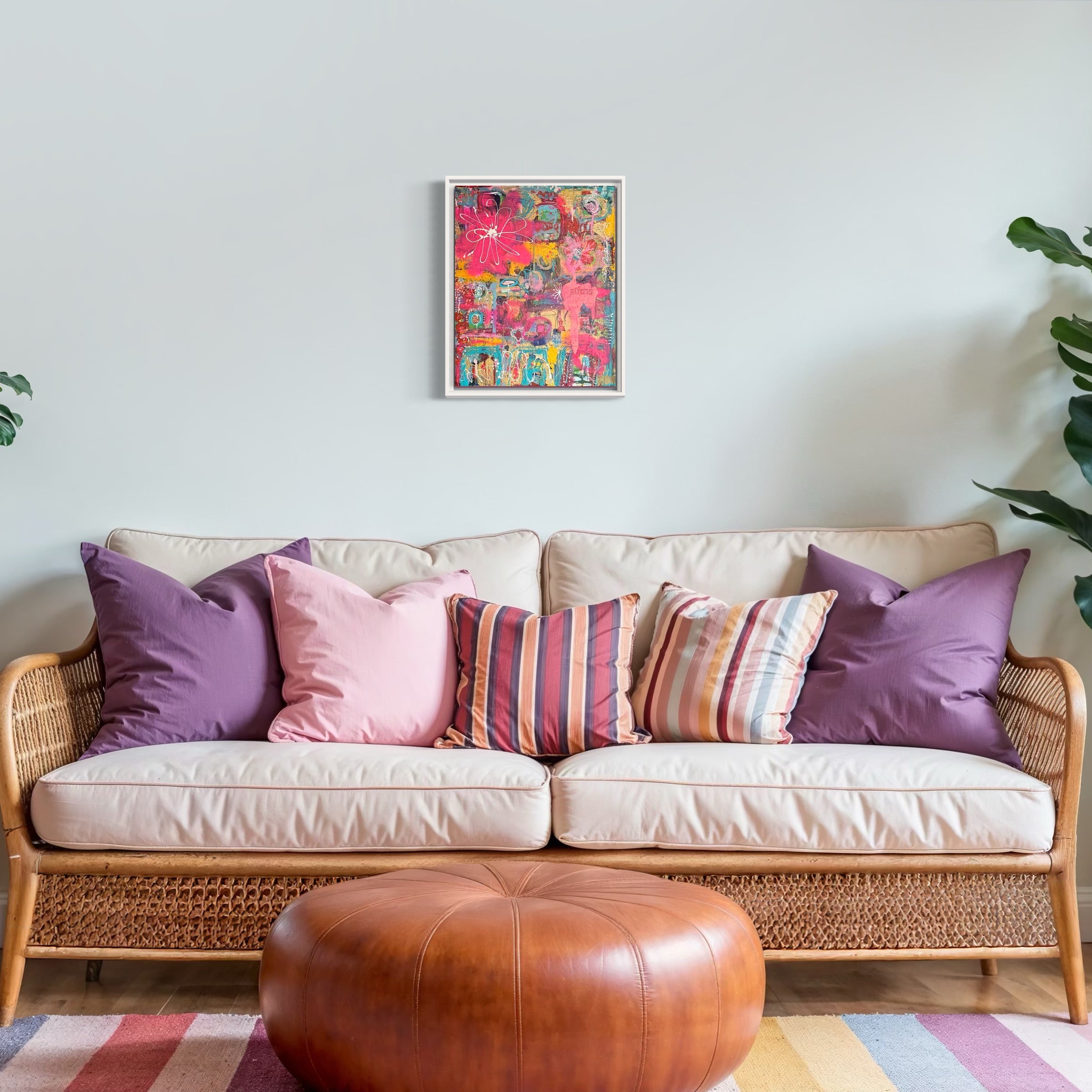 Living room with a wicker sofa, colorful cushions, and plants.
