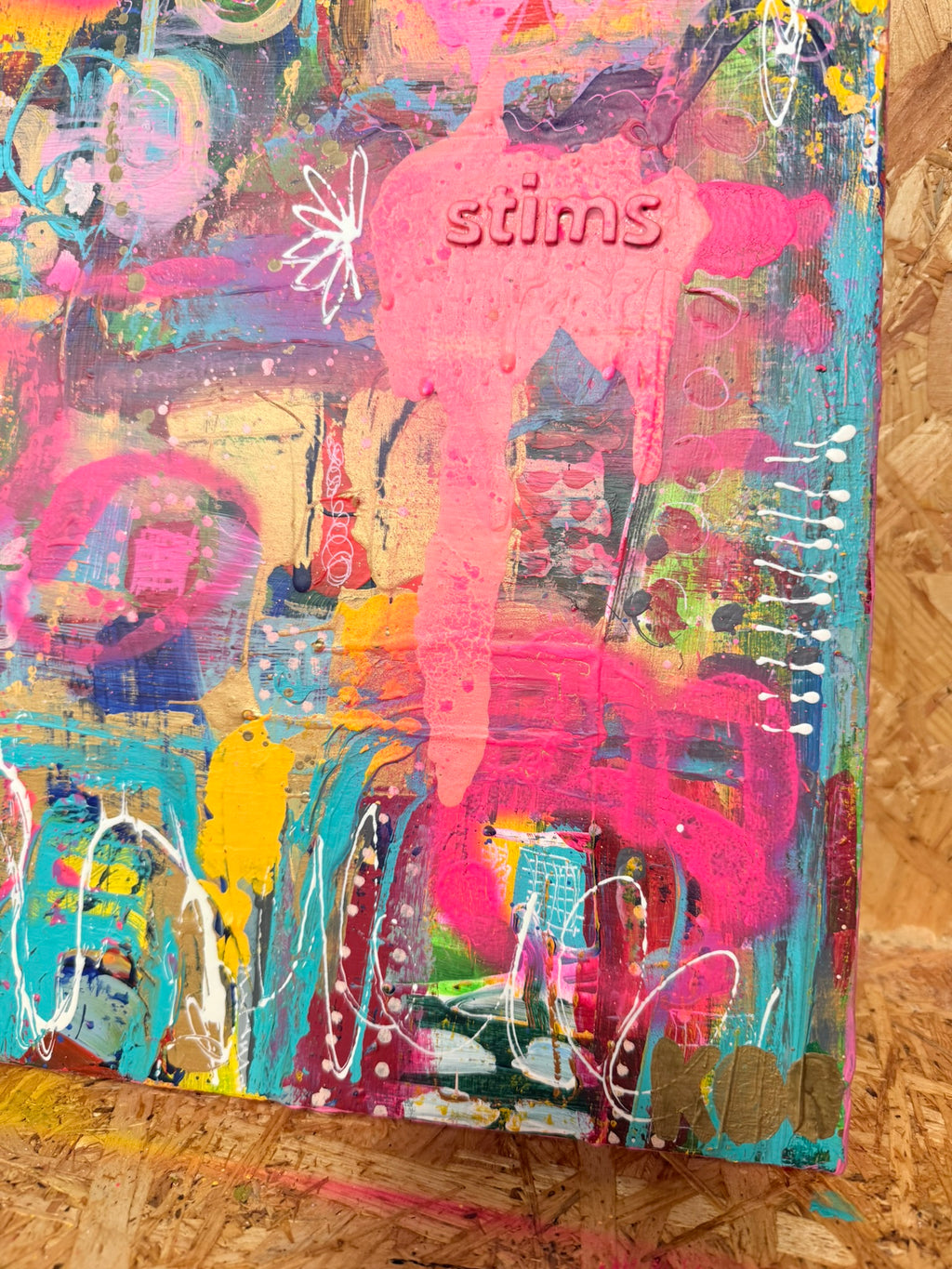 Colorful abstract art piece with 'stims' branding on a canvas
