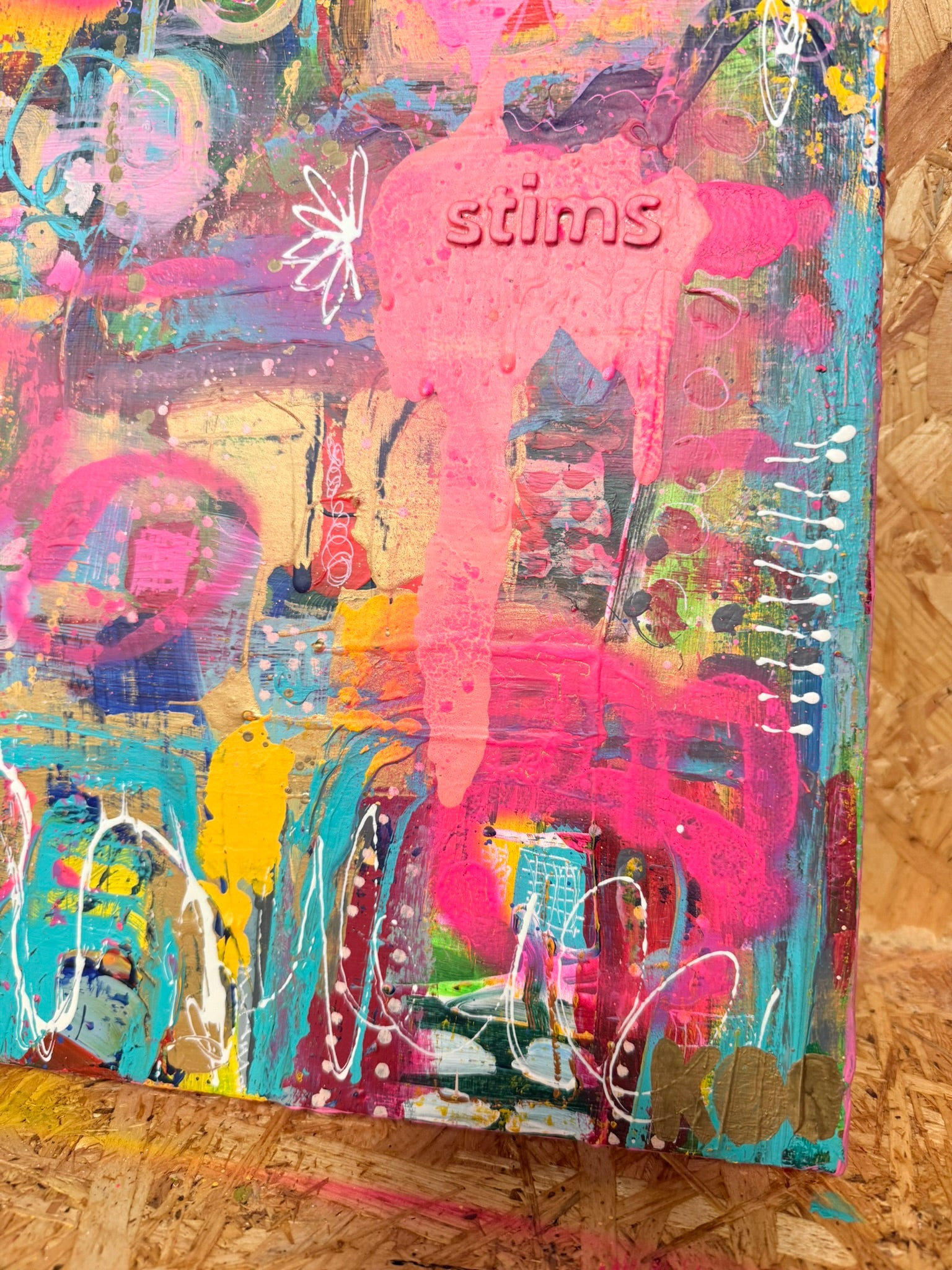 Colorful abstract art piece with 'stims' branding on a canvas